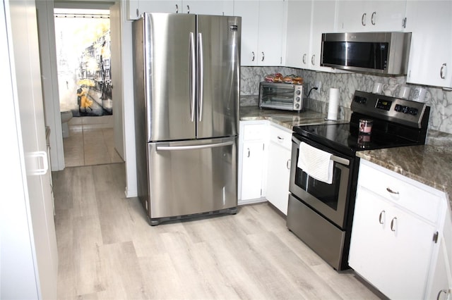 8650 SW 108th Pl, Ocala, FL 34481 - kitchen with appliances with stainless steel finishes, light wood-style flooring, white cabinetry, and tasteful backsplash