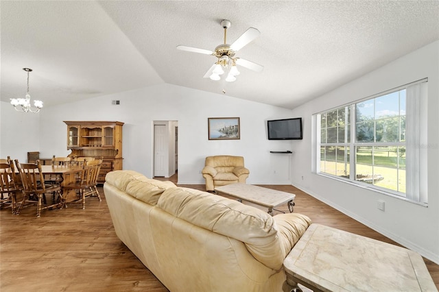 475 NE 155th Pl, Citra, FL 32113 - living room featuring vaulted ceiling, a chandelier, a textured ceiling, wood finished floors, and a ceiling fan