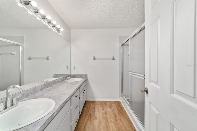 475 NE 155th Pl, Citra, FL 32113 - full bath with double vanity, a textured ceiling, wood finished floors, and tiled shower