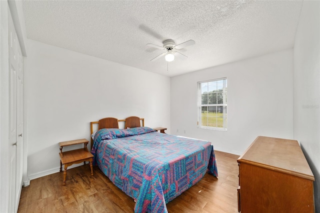 475 NE 155th Pl, Citra, FL 32113 - bedroom with wood finished floors, a textured ceiling, and a ceiling fan