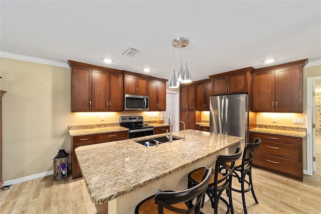 19130 NW 60th Ave, Reddick, FL 32686 - kitchen with stainless steel appliances, ornamental molding, light wood-style floors, a kitchen breakfast bar, and hanging light fixtures