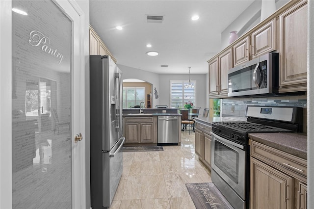 15549 SW 11th Terrace Rd, Ocala, FL 34473 - kitchen featuring appliances with stainless steel finishes, arched walkways, recessed lighting, dark countertops, and tasteful backsplash