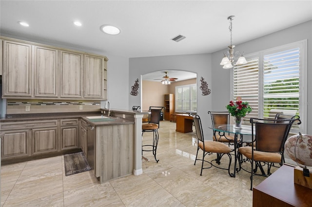 15549 SW 11th Terrace Rd, Ocala, FL 34473 - kitchen with a peninsula, a breakfast bar area, dark countertops, arched walkways, and healthy amount of natural light