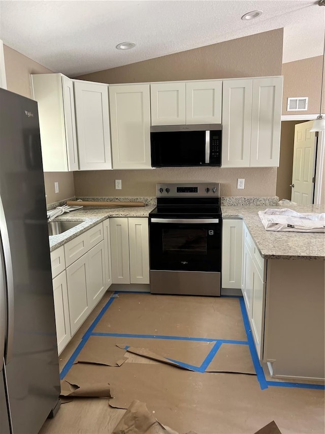 19622 SW Marine Blvd, Dunnellon, FL 34431 - kitchen featuring stainless steel appliances, a peninsula, white cabinetry, and a textured ceiling
