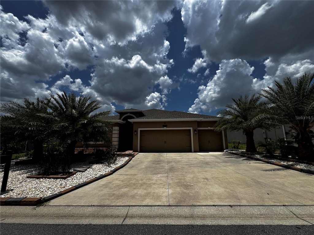 9238 SW 60th Court Rd, Ocala, FL 34476 - view of front of home featuring stucco siding, an attached garage, and driveway