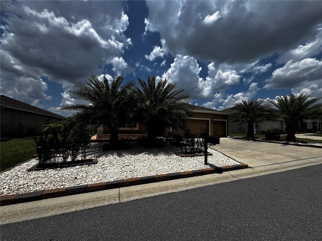 9238 SW 60th Court Rd, Ocala, FL 34476 - view of property hidden behind natural elements with concrete driveway, a garage, and stucco siding