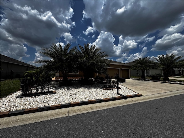 9238 SW 60th Court Rd, Ocala, FL 34476 - view of property hidden behind natural elements with concrete driveway, a garage, and stucco siding