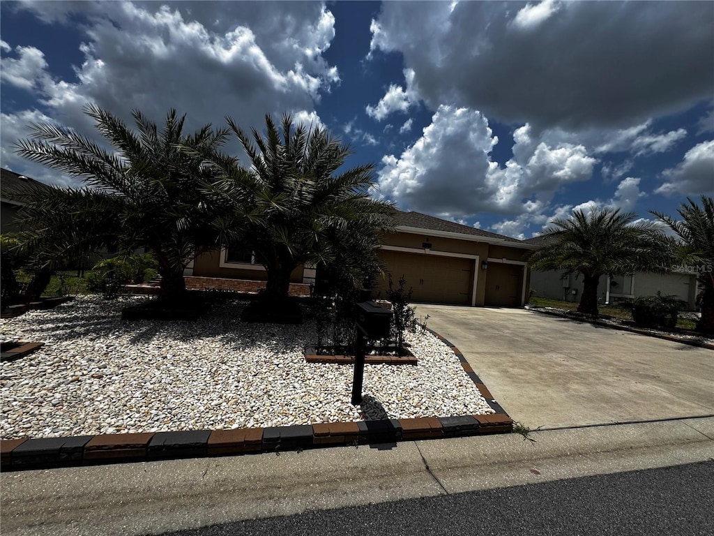 9238 SW 60th Court Rd, Ocala, FL 34476 - view of property hidden behind natural elements with driveway, a garage, and stucco siding
