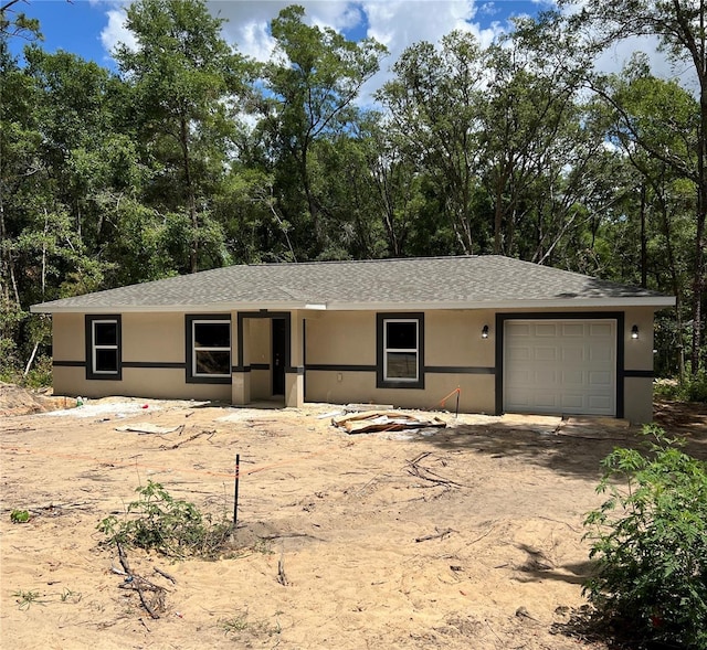 20769 SW Oriole Dr, Dunnellon, FL 34431 - view of front facade with stucco siding, a garage, and a shingled roof
