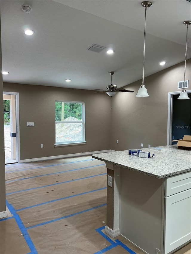 20769 SW Oriole Dr, Dunnellon, FL 34431 - kitchen featuring white cabinets, plenty of natural light, light stone countertops, recessed lighting, and pendant lighting