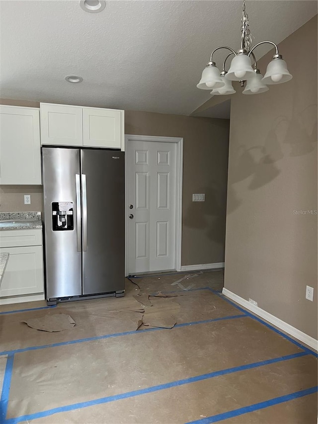 20769 SW Oriole Dr, Dunnellon, FL 34431 - kitchen featuring stainless steel fridge, a chandelier, white cabinetry, a textured ceiling, and pendant lighting