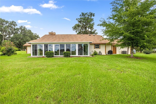 12131 NE 10th Ter, Ocala, FL 34479 - rear view of property with a lawn, a chimney, stucco siding, and a sunroom