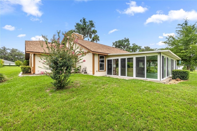 12131 NE 10th Ter, Ocala, FL 34479 - rear view of property with a sunroom, a chimney, stucco siding, and a yard