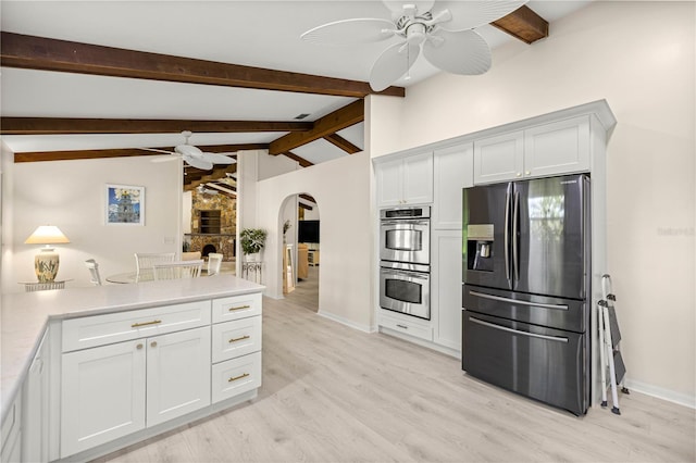 12131 NE 10th Ter, Ocala, FL 34479 - kitchen featuring appliances with stainless steel finishes, a ceiling fan, arched walkways, light wood-style flooring, and light countertops