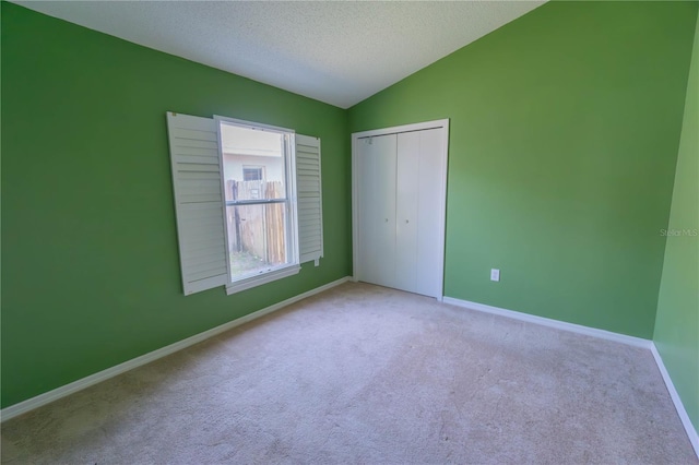 949 Woodsong Way, Clermont, FL 34714 - unfurnished bedroom featuring carpet, a closet, vaulted ceiling, and a textured ceiling
