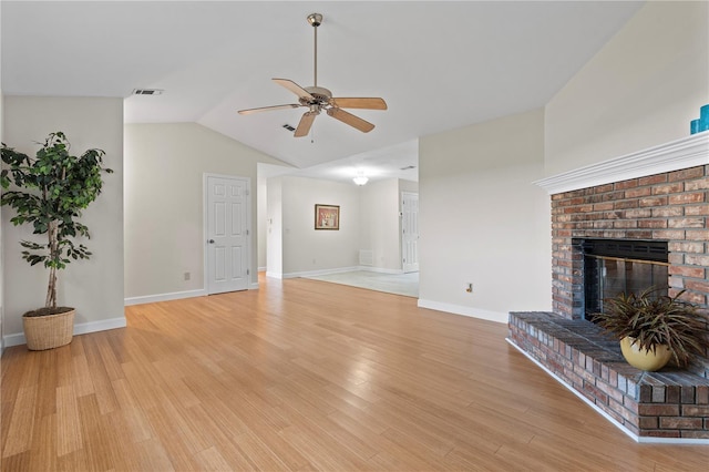 2864 SW 40th Ave, Gainesville, FL 32608 - unfurnished living room with a ceiling fan, a brick fireplace, vaulted ceiling, and light wood-style floors