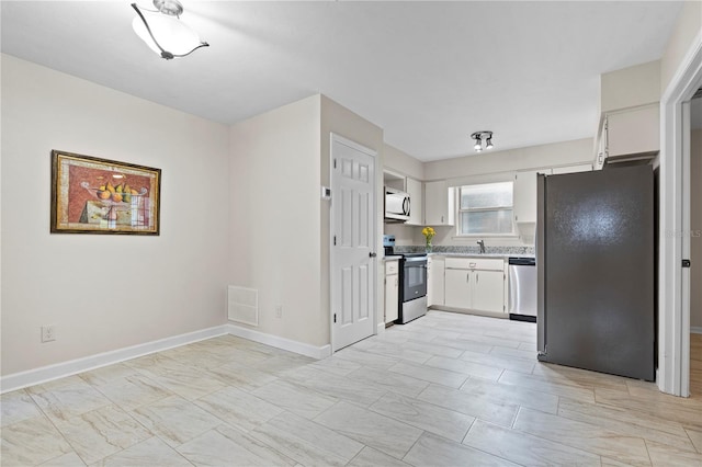 2864 SW 40th Ave, Gainesville, FL 32608 - kitchen with appliances with stainless steel finishes, white cabinetry, and light countertops