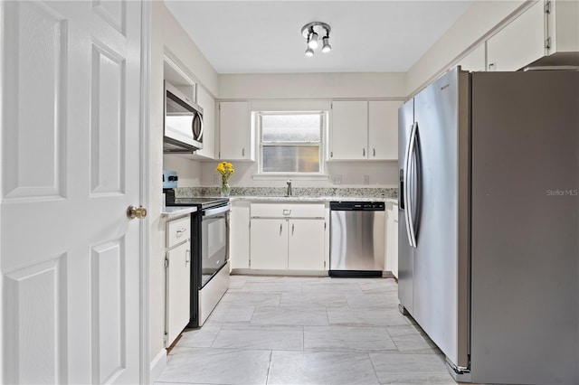 2864 SW 40th Ave, Gainesville, FL 32608 - kitchen featuring appliances with stainless steel finishes, white cabinetry, and light stone countertops