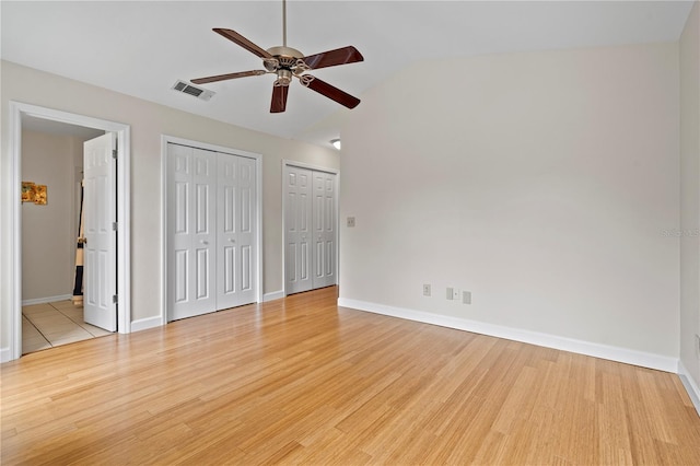2864 SW 40th Ave, Gainesville, FL 32608 - unfurnished bedroom featuring multiple closets, light wood-style flooring, lofted ceiling, connected bathroom, and ceiling fan