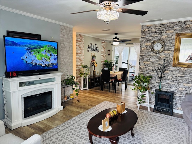 8547 SW 106th Pl, Ocala, FL 34481 - living room with ceiling fan, crown molding, wood finished floors, a wood stove, and a fireplace