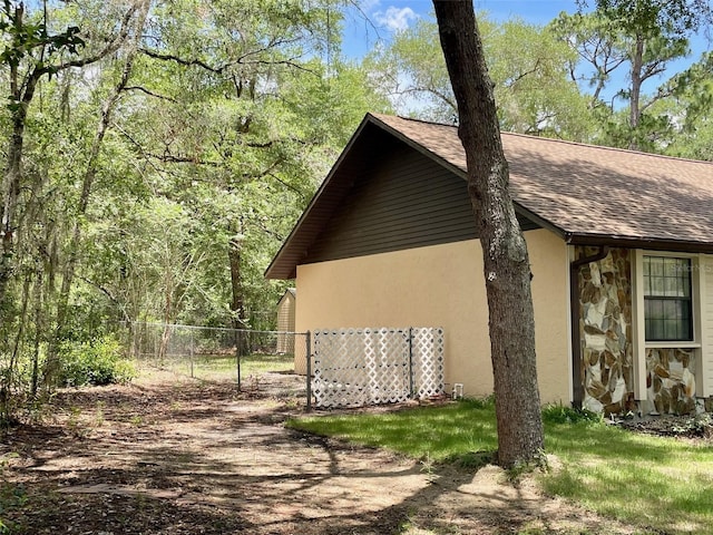1112 NE 130th Ter, Silver Springs, FL 34488 - view of side of home featuring stone siding, roof with shingles, and stucco siding