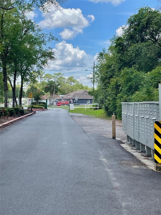 1112 NE 130th Ter, Silver Springs, FL 34488 - view of asphalt road with street lights and a gated entry