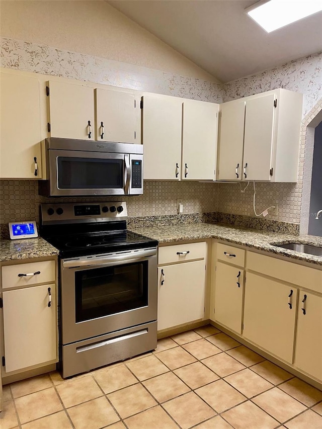1112 NE 130th Ter, Silver Springs, FL 34488 - kitchen featuring stainless steel appliances, vaulted ceiling, decorative backsplash, and light tile patterned floors