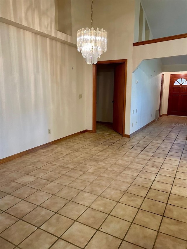 1112 NE 130th Ter, Silver Springs, FL 34488 - spare room featuring a towering ceiling, a chandelier, and light tile patterned floors