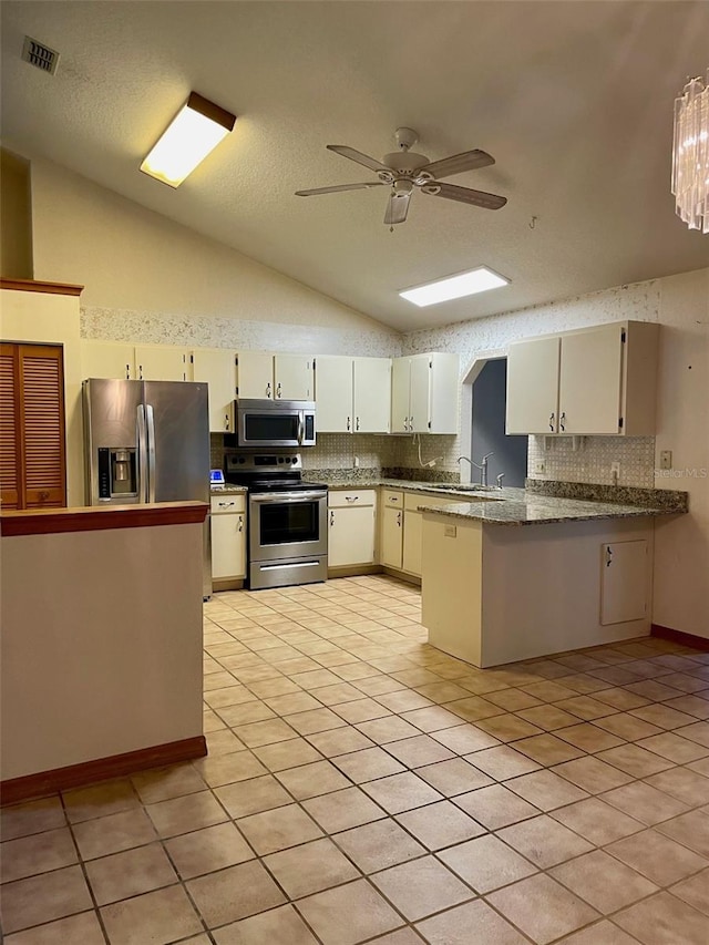 1112 NE 130th Ter, Silver Springs, FL 34488 - kitchen with stainless steel appliances, lofted ceiling, backsplash, ceiling fan, and a peninsula