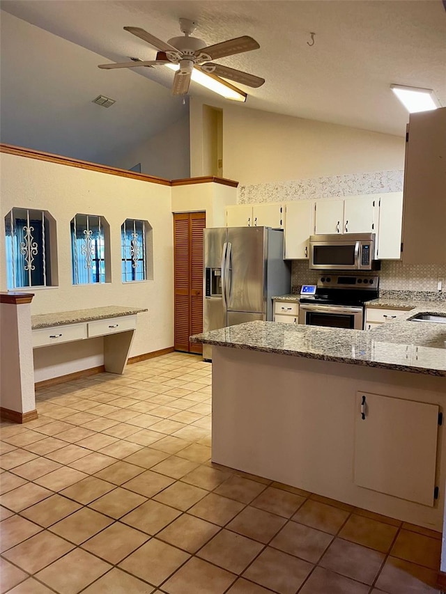 1112 NE 130th Ter, Silver Springs, FL 34488 - kitchen featuring appliances with stainless steel finishes, white cabinetry, light stone counters, a peninsula, and tasteful backsplash