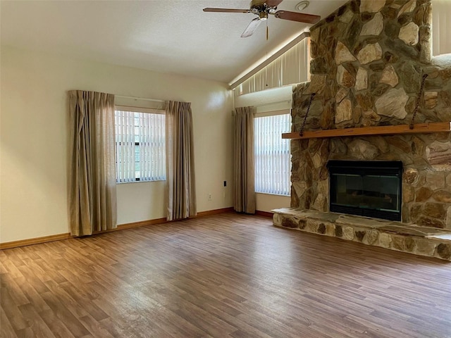 1112 NE 130th Ter, Silver Springs, FL 34488 - unfurnished living room with vaulted ceiling, wood finished floors, healthy amount of natural light, a ceiling fan, and a stone fireplace