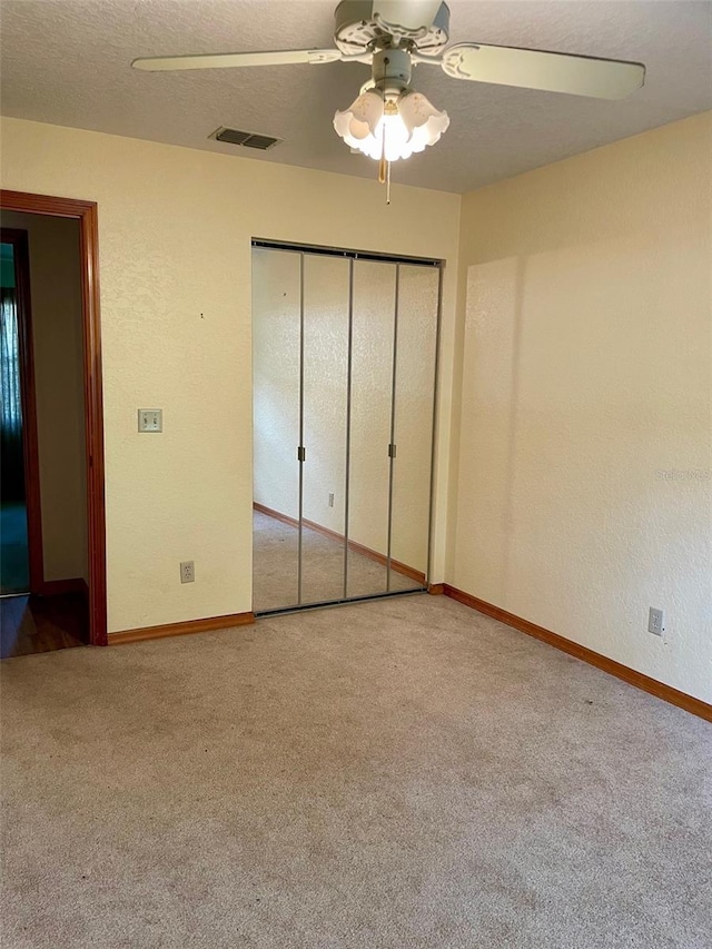 1112 NE 130th Ter, Silver Springs, FL 34488 - unfurnished bedroom with carpet floors, a closet, a textured wall, a textured ceiling, and a ceiling fan