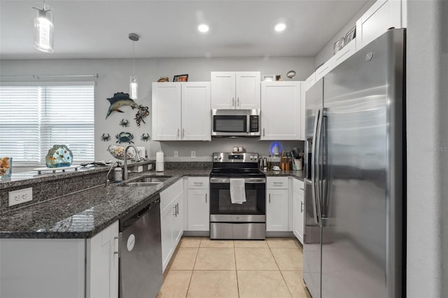 14347 Easy Goer St, Ruskin, FL 33573 - kitchen with stainless steel appliances, light tile patterned floors, a peninsula, white cabinetry, and recessed lighting
