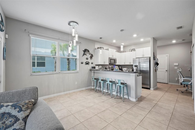 14347 Easy Goer St, Ruskin, FL 33573 - kitchen with stainless steel appliances, recessed lighting, a peninsula, a kitchen breakfast bar, and light tile patterned floors