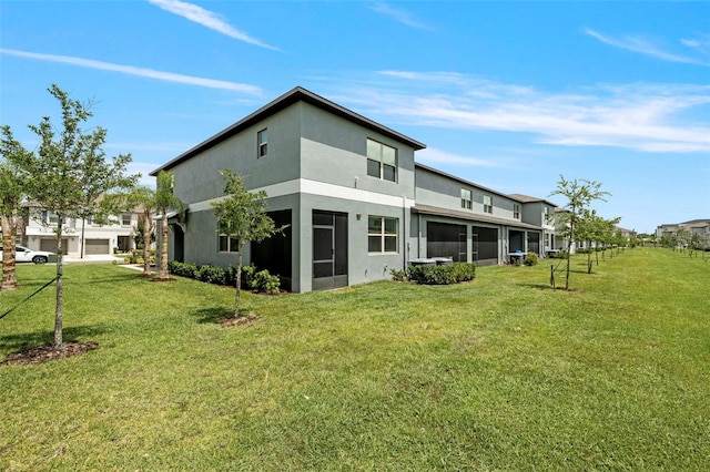 14347 Easy Goer St, Ruskin, FL 33573 - back of house featuring stucco siding and a yard