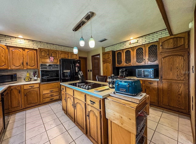 3545 SE 24th Ave, Ocala, FL 34471 - kitchen with black appliances, a center island, brown cabinetry, a textured ceiling, and light countertops
