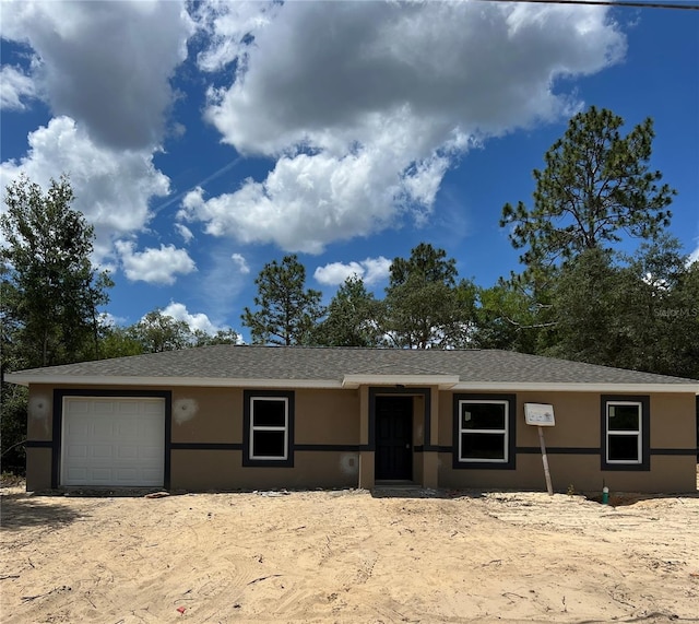 21712 SW Rainbow Lakes Blvd, Dunnellon, FL 34431 - view of front facade featuring an attached garage, stucco siding, and roof with shingles