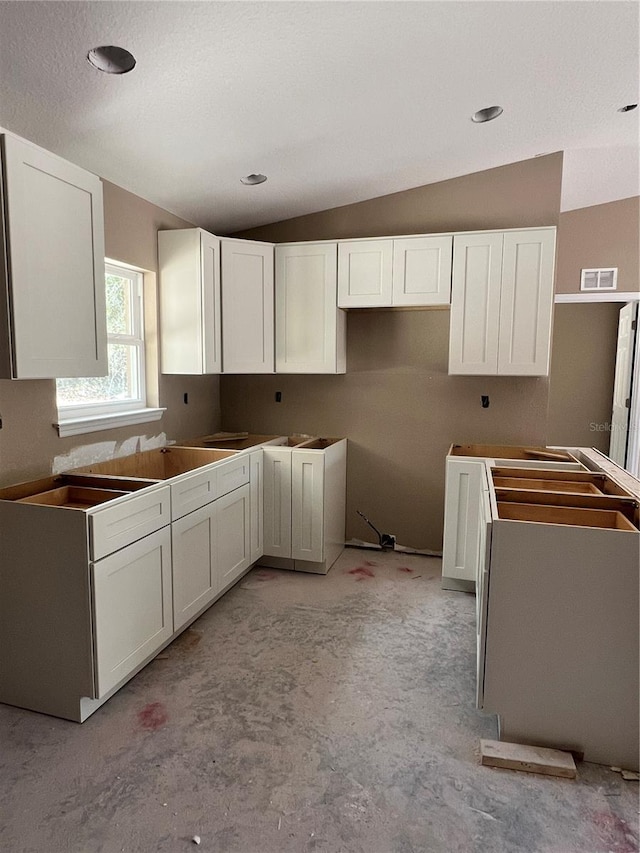 21712 SW Rainbow Lakes Blvd, Dunnellon, FL 34431 - kitchen featuring vaulted ceiling, white cabinets, and light colored carpet