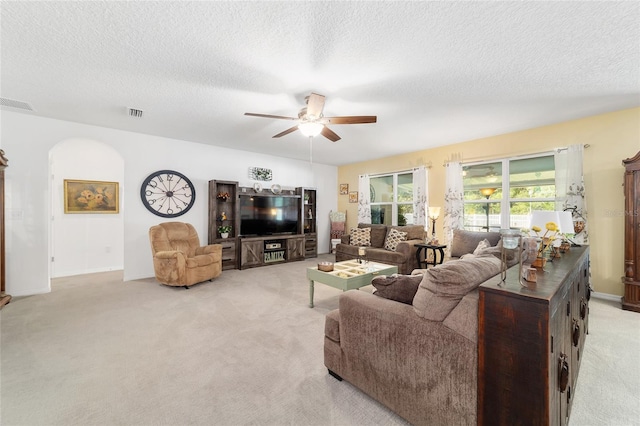 2552 NE 42nd Rd, Ocala, FL 34470 - living area featuring light carpet, ceiling fan, a textured ceiling, and arched walkways