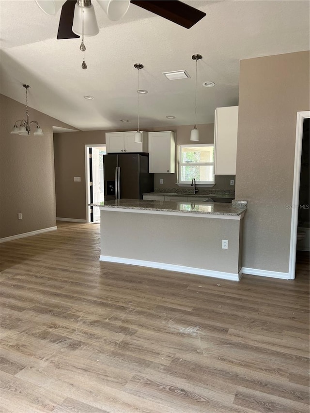 10375 SE 126th Ln, Belleview, FL 34420 - kitchen featuring fridge with ice dispenser, white cabinets, ceiling fan, light wood-type flooring, and pendant lighting
