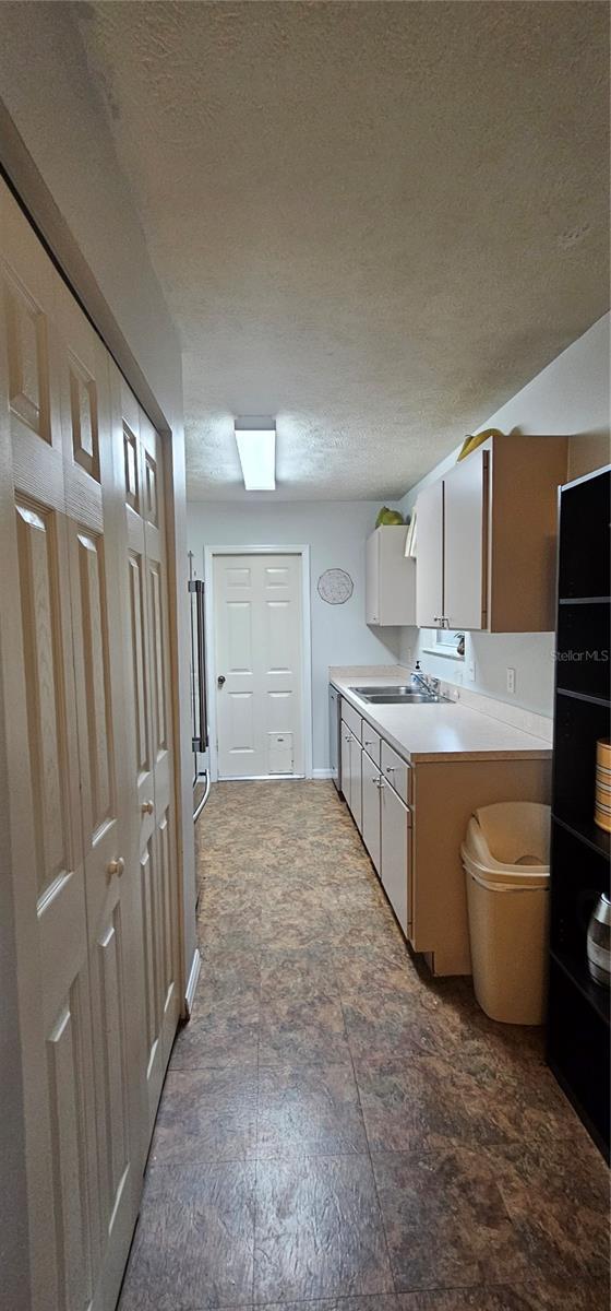 5591 NW 61st Ln, Ocala, FL 34482 - kitchen with a textured ceiling, light countertops, and stainless steel dishwasher