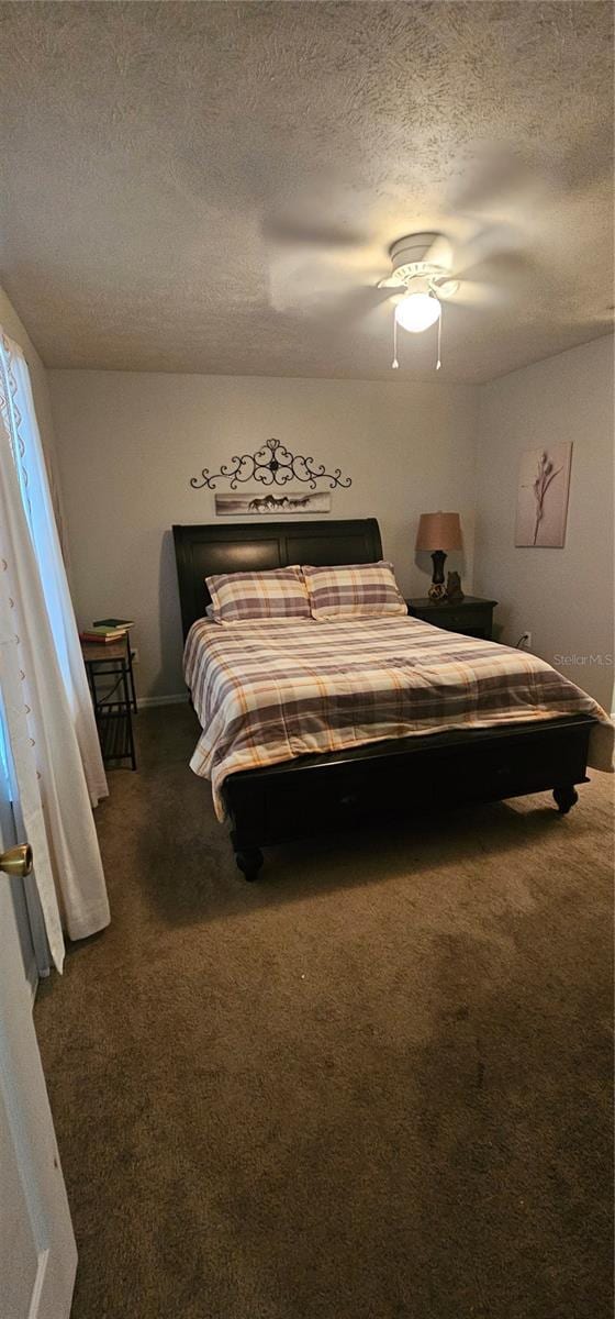 5591 NW 61st Ln, Ocala, FL 34482 - bedroom featuring dark carpet, a textured ceiling, and a ceiling fan