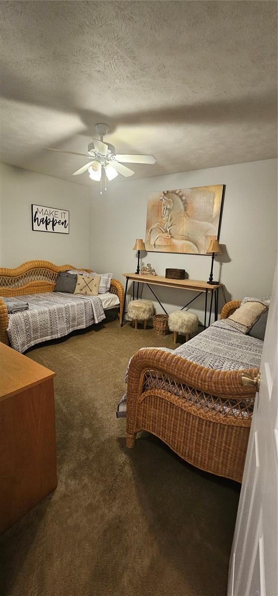 5591 NW 61st Ln, Ocala, FL 34482 - bedroom featuring carpet floors, ceiling fan, and a textured ceiling