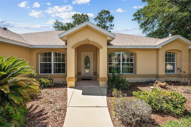 4300 NW 4th Cir, Ocala, FL 34475 - doorway to property featuring a shingled roof and stucco siding