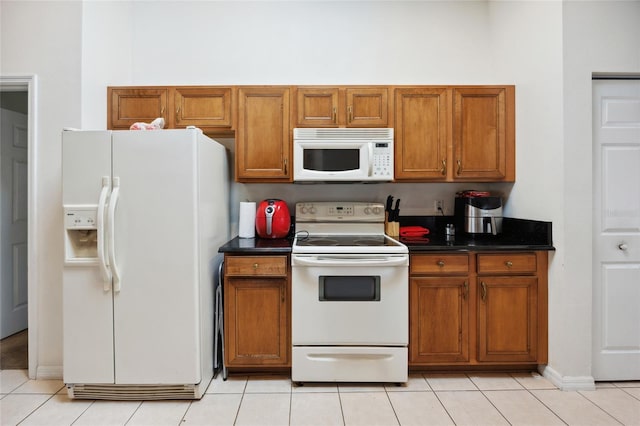 4300 NW 4th Cir, Ocala, FL 34475 - kitchen featuring white appliances, brown cabinetry, dark countertops, and light tile patterned floors