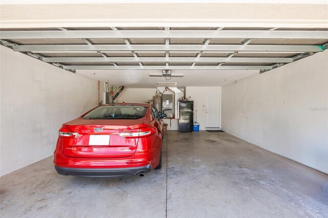 4300 NW 4th Cir, Ocala, FL 34475 - garage featuring electric water heater, a garage door opener, and freestanding refrigerator