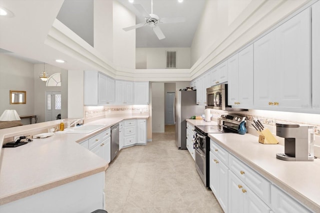 4322 N Mayan Dr, Hernando, FL 34442 - kitchen featuring stainless steel appliances, a high ceiling, white cabinetry, ceiling fan, and light countertops