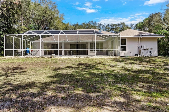 4322 N Mayan Dr, Hernando, FL 34442 - back of house featuring a lawn, stucco siding, and glass enclosure