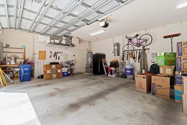 4322 N Mayan Dr, Hernando, FL 34442 - garage featuring a garage door opener, freestanding refrigerator, water heater, and a workshop area
