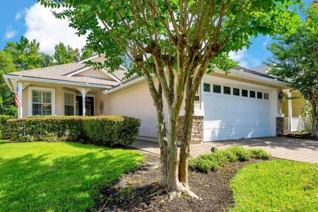 814 Copperhead Cir, Saint Augustine, FL 32092 - view of front of house featuring an attached garage, a front yard, driveway, stone siding, and stucco siding
